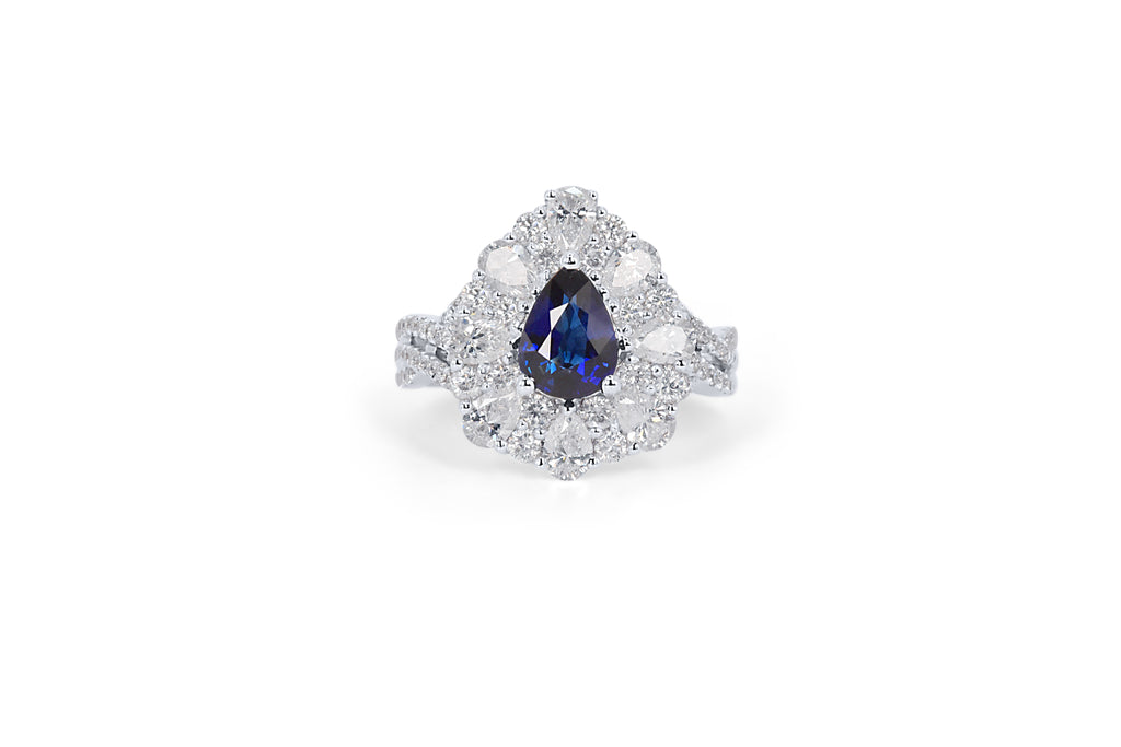 A custom made diamond and sapphire halo style engagement ring with a sapphire at the centre and diamonds surrounding