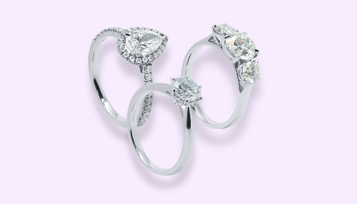 Halo pear diamond engagement ring with diamond shoulders and platinum band, diamond trilogy round ring and a solitaire round brilliant engagement ring with a platinum band.