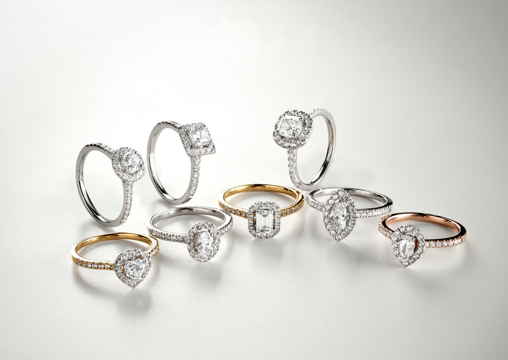 Wide shot of all diamond engagement ring shapes and styles with yellow gold and platinum bands.